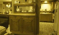 1927 Antique oak sideboard with pineapple feet. Two piece, top has sliding glass beveled doors with mirror on backside. Bottom piece has marble top with two drawers and two large doors for holding your fine china or other items. Dimensions are 65" high,