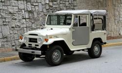 FJ40 clad in Dune Beige with a grey soft top. Equipped with both power steering and power disc brakes, it's had a few upgrades as a nod to modern convenience without losing its vintage bona fides. Paint quality is outstanding; the truck saw a frame-off,