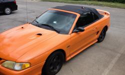 1998 Orange & Black Ford Mustang With 99 Miles . It Drives Wonderful , It Has A Performance Chip , Rearview Back Up Camera And A Racing Rear End , Also A 9 Inch Filp Out Tv Radio . The Top Still Let's Down Easliy .