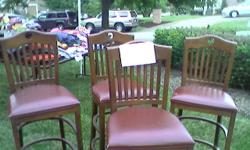 Four solid wood leather seat bar stools, good condition.