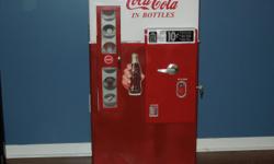 Replica 1950-60's Coca Cola machine bookcase/toy storage. This stands 48" tall, 24.5" wide and 17" deep. This has the original paint scheme and decals. The coin return and bottle opener are functional. There&nbsp;are six bottles turned on a lathe with