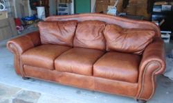 This sofa is a traditionally styled brown leather with ornamental studded arms. The sofa is just 5 years old and hardly used so the condition is extremely good. It is a deal at $350 a wood coffee table with class top is also available for $125.