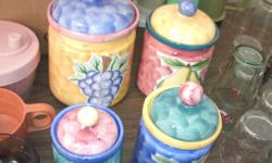 Nice 4 piece canister set. Gold pottery with different fruit on each piece. Largest measures 6 1/2" tall. Very old, but in new condition.