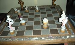 Hand made chess game is made out of wood and 22 inches long by 21.5 inches wide. Each chess piece is a design of a sea shell.The blocks are made out of colored sand, chess pieces are stored inside chess set.