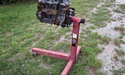 Red engine stand with 4 cylinder engine attached. Sturdy, Can be rolled to any part of garage. Local pick up only