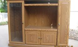 Entertainment center with an overall size of 66" Wide, 19 1/2" Deep, and 52" High. The opening size for a TV is 33" Wide, 18" Deep, and 23 1/2" High. The cabinet is in good shape. Right side shelves have storage for DVDs and VHS tapes. Additional shelve