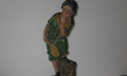 CHALK OR PLASTER FIGURE OF A LADY TENNIS PLAYER LIKE YOU MIGHT GET FROM A FAIR,BOUGHT FROM WOMAM FROM GERMANY,IVE HAD IT ABT 40 YEARS,DONT KNOW HOW OLD IT IS.ABT 12 IN TALL DARK GREEN DRESS.