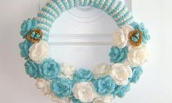 Here is a handmade 14" crochet turquoise and white wreath with roses and two little birds nest on each side.
Made with worst weight yarn, the cover of the wreath is light turquoise (almost light blue) and white. Around the wreath are turquoise and white