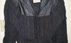 Ladies Black Leather jacket. This is a vest cut, fringe, dress, jacket. Has heavy duty snaps, not a zipper and is in great condition.
The jacket is a combination of soft suede and tanned leather. There are two small pockets.
None of the fringe is missing