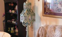 Beautiful large ornate and crystal lamp. The lamp is 44" tall and 14" at the widest area. It has a 5 bulb candelabra on the lower portion and 2 bulbs on top. The 400 crystals sparkle both on and off. There is a three way switch lighting lower, upper or