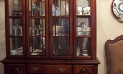30 year old Large Queen Ann 18th century style cherry wood china cabinet.
Base has 4 large center drawers with left and right storage cabinet with doors.
Both lower cabinets have one interior glass shelf inside.
Top half of china hutch has two glass