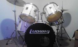 Five piece, white, 1994 Ludwig Rockers. One floor tom, two rack toms, snare, floor bass,&nbsp;high-hat, and symbol. symbol and high-hat Zildjians.