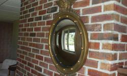 Curved mirror in a gold eagle frame. &nbsp;Interesting piece.