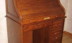 Oak rolltop desk with lighted work surface. Measures 46" tall, 36" wide, 23" deep. Bottom drawer is a hanging file drawer. Both the rolltop and the file drawer lock with key. Like new condition. $275.
