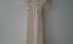 Is delicate material very golden shiny and cream color is a size small 5ft long dress is crossed in the back