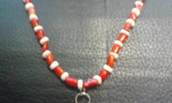 Hand made from red coral and wight seashell beads. Accented with silver plat clasp and findings. The pendant is made from a genuine Ibanez guitar pick. If you would like to see more handcrafted jewelry please visit us at: fireforgehandcraftedjewelry.com