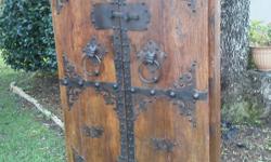 Solid wood (elm) pair of rustic Asian/Chinese doors with ironwork. Although refinished there is significant wear, particularly to the iron. However, as you can see in the pictures, this adds to a charming, rustic character of these doors. The large iron
