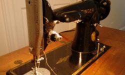 Early Model Singer sewing machine in wood cabinet.&nbsp; Working condition.
&nbsp;