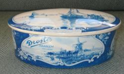 Vintage oval tin Droste Haarlem Holland , blue and white with removable lid. Size about 7 inches by 4 1/2 inches by 2 inches, top and sides have scenes of ships, windmills and cattle, good condition