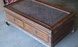 This table is wood with a rattan wood pattern on top lies a glass top. There are two drawer that are great for storage. The table needs a little TLC with some restaining. Just $75.