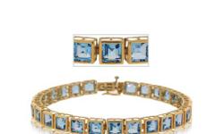 Wrap your wrist with the captivating color of the Carribean. This Blue Topaz bracelet boasts over nine carats of glimmering princess-cut gemstones. The raised-box settings in polished yellow Gold make each stone really stand out. Make your own waves with